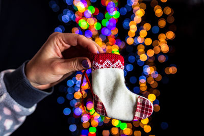 Midsection of person holding illuminated christmas lights