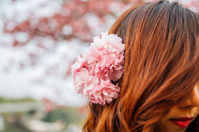 Close-up portrait of woman with flower in hair