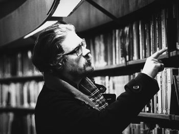 Side view of thoughtful man in library