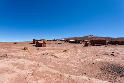 Built structure on desert against clear blue sky