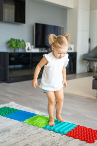 Side view of boy playing with toy on floor