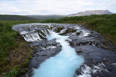 Scenic view of waterfall against sky