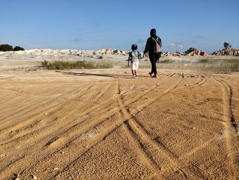 Rear view of couple walking on land