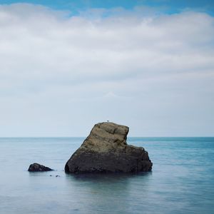 Rock formation in sea against sky