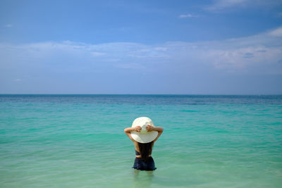 Rear view of woman standing in sea