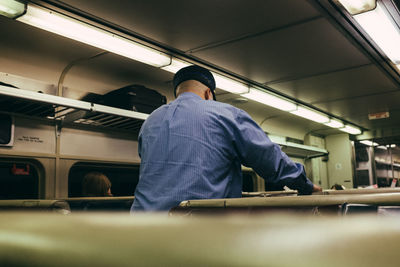 Rear view of man working in train