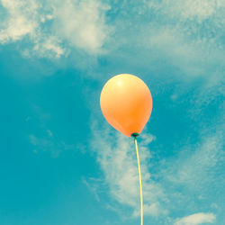 Low angle view of balloons against blue sky