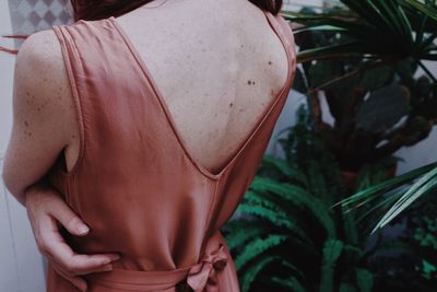 Rear view of woman standing against plants