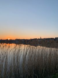 Scenic view of lake against clear sky during sunset