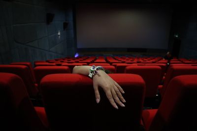 Cropped hand watching movie in theater