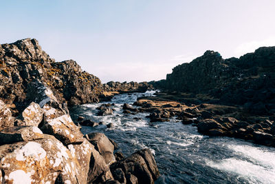 Rocks on beach against sky