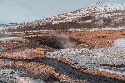 Scenic view of hot spring against sky