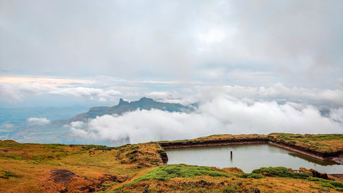 Scenic view of waterfall against sky