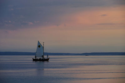 Sailboat sailing on sea against sky during sunset