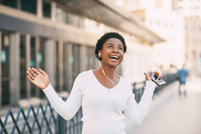 Young woman using mobile phone standing in city