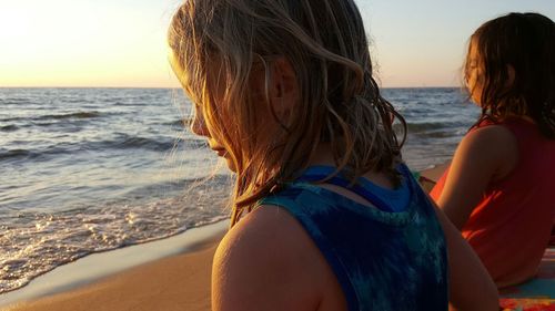 Sisters with wet hair on shore at beach