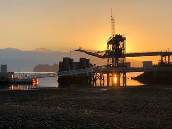 Bridge over river against sky during sunset