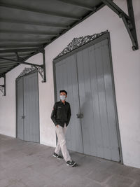 Full length portrait of young man standing against ceiling