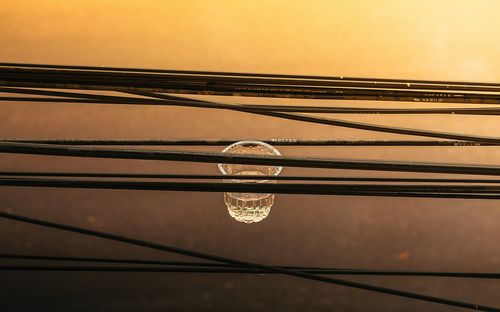 Close-up of light bulb against sky during sunset