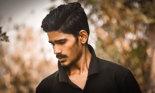 Portrait of young man looking away outdoors