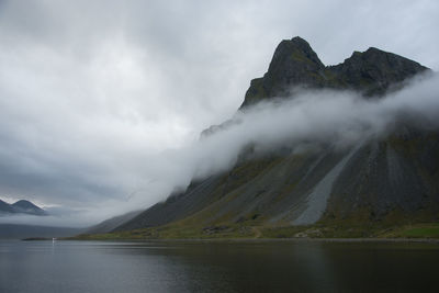 Scenic view of lake by mountains against sky