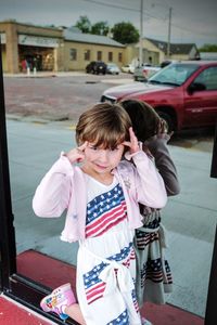 Portrait of girl making face against glass window