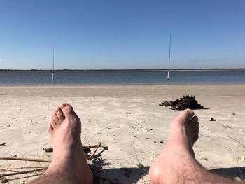 Low section of man relaxing on beach