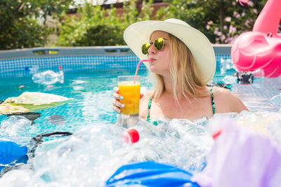 Woman wearing hat by swimming pool