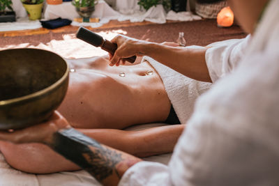 Midsection of woman lying on bed