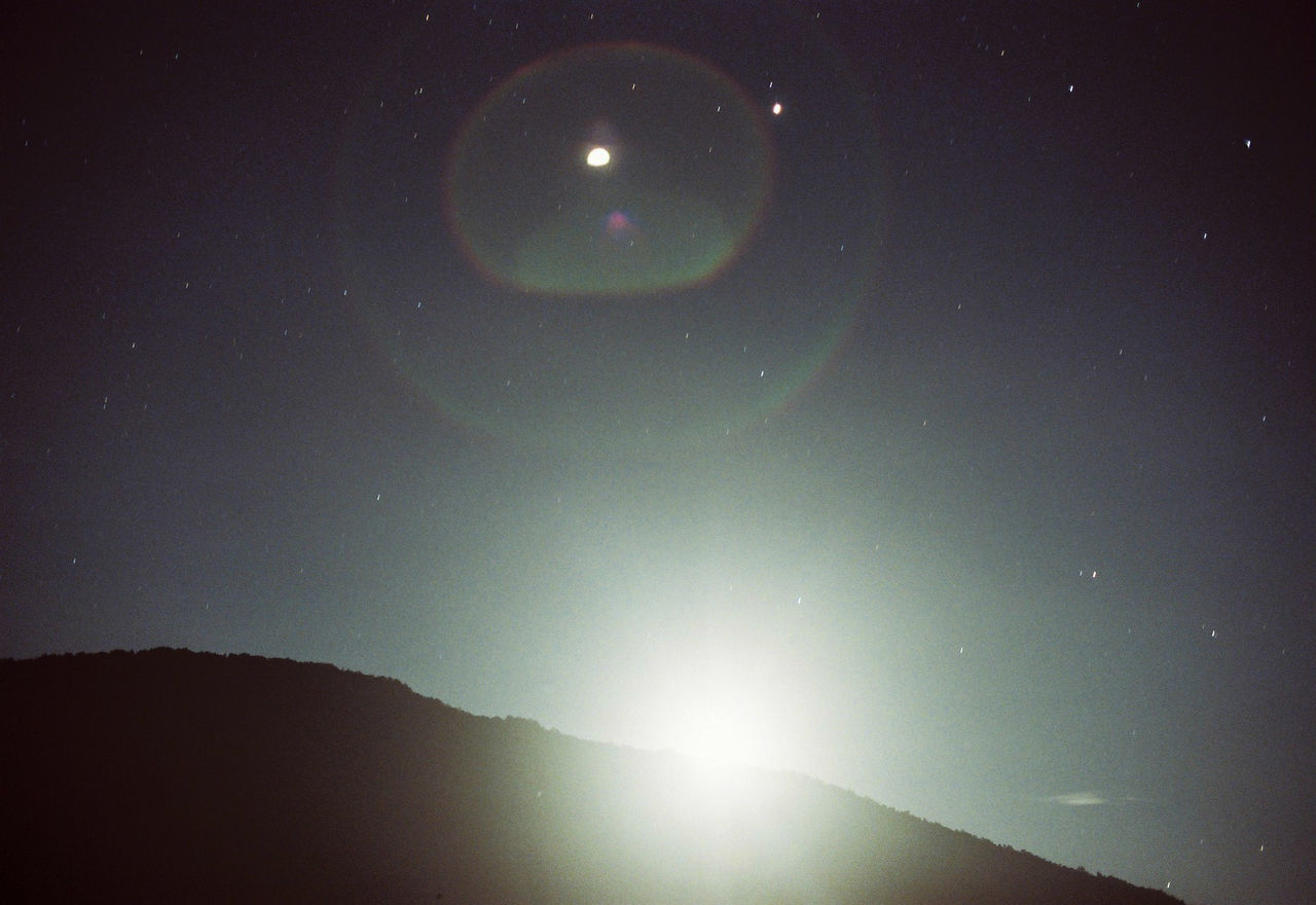 sky, astronomy, beauty in nature, night, space, scenics - nature, tranquility, nature, tranquil scene, star - space, no people, lens flare, idyllic, low angle view, moon, natural phenomenon, outdoors, mountain, star, bright, moonlight, planetary moon, eclipse