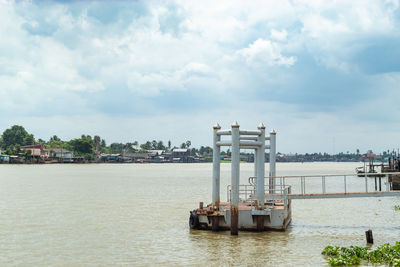 Boat in sea against cloudy sky