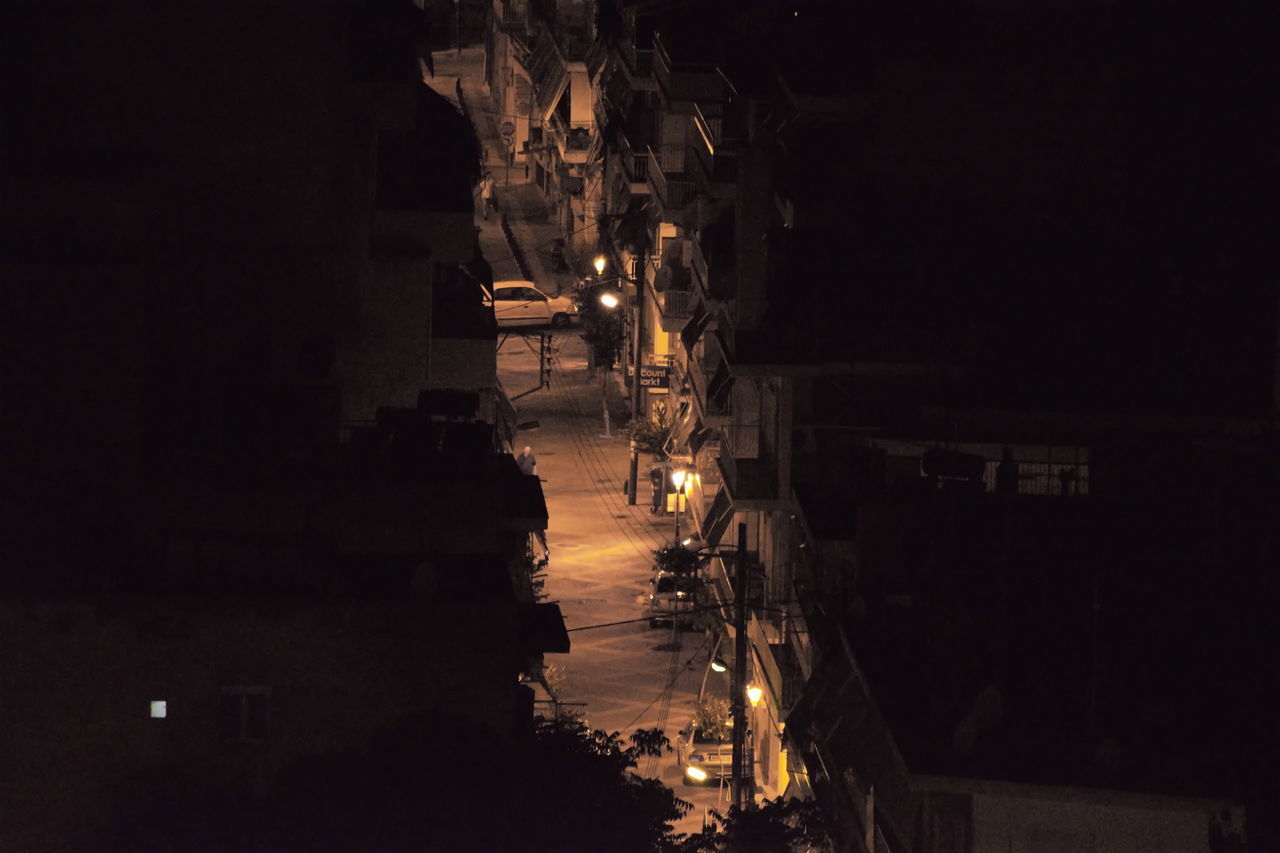 ILLUMINATED STREET LIGHT BY BUILDING AT NIGHT