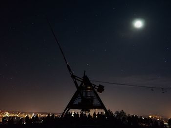 Low angle view of illuminated windmill against sky at night