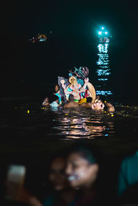 People swimming in sea at night