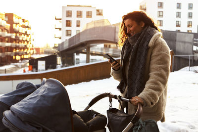 Woman with pram using phone