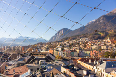Aerial landmark of innsbruck through the barrier net. panorama of old town and alps mountains.
