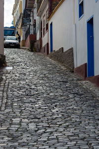 Surface level of cobblestone street amidst buildings