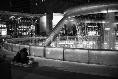 People sitting in illuminated city at night