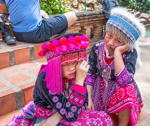 Midsection of friends sitting in traditional clothing