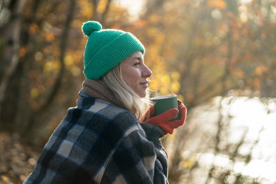 Rear view of woman standing against trees