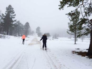 People walking on snow covered landscape