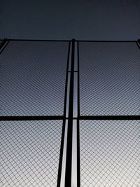 Low angle view of chainlink fence against sky