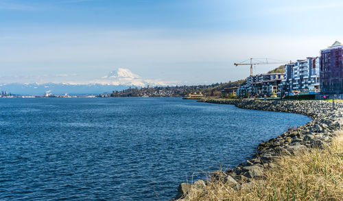 Scenic view of sea by buildings against sky