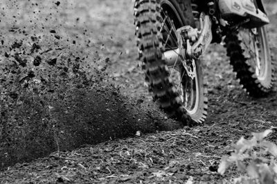 Cropped image of person riding bicycle on field