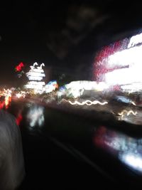 Defocused image of illuminated city against sky at night