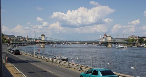 Bridge over river in city against sky