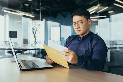 Portrait of young man using laptop at table