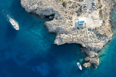 Drone aerial  cape greko peninsula   agioi anargyroi church on the rocks. cruise boats sailing.