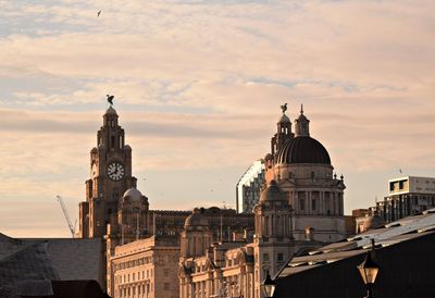 Buildings in city against sky during sunset