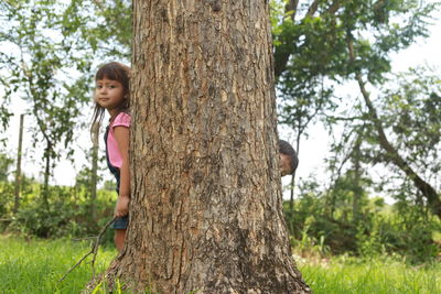 Girl looking at tree trunk